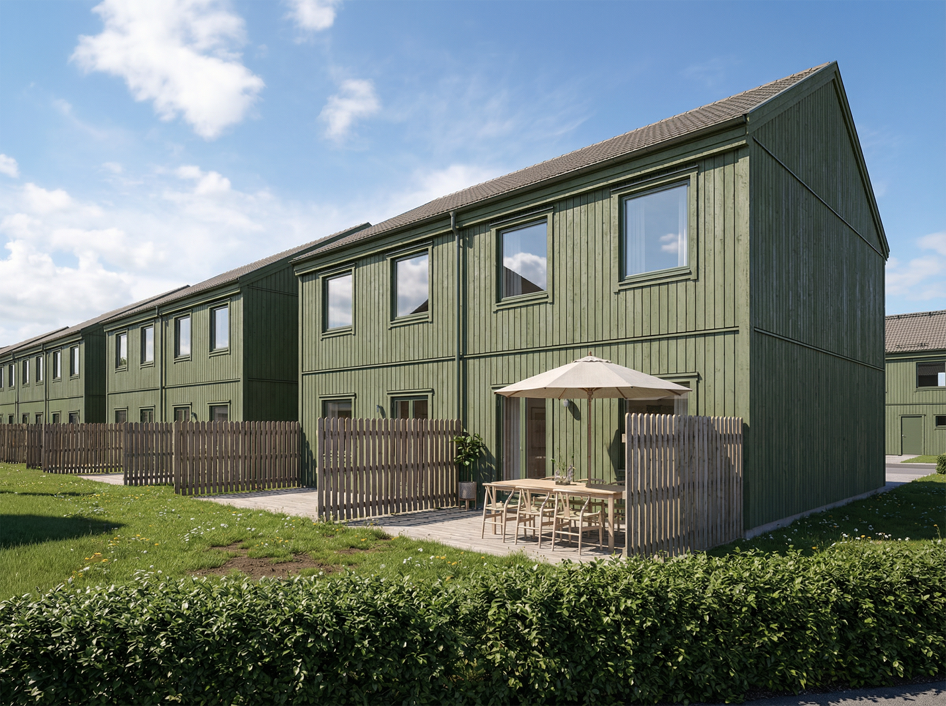 Bild på en sommardag och ett villaområde, med gröna parhus.